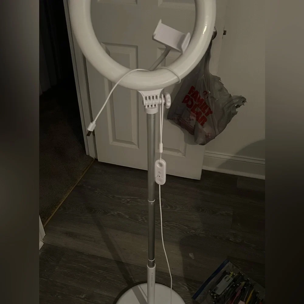 This is a standing ring light with a phone holder accessory with a remote also